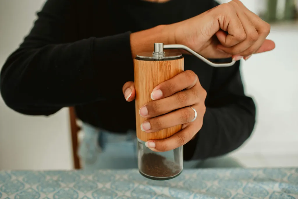 Moedor de café manual com mó cônica sendo usado para preparar café especial em casa